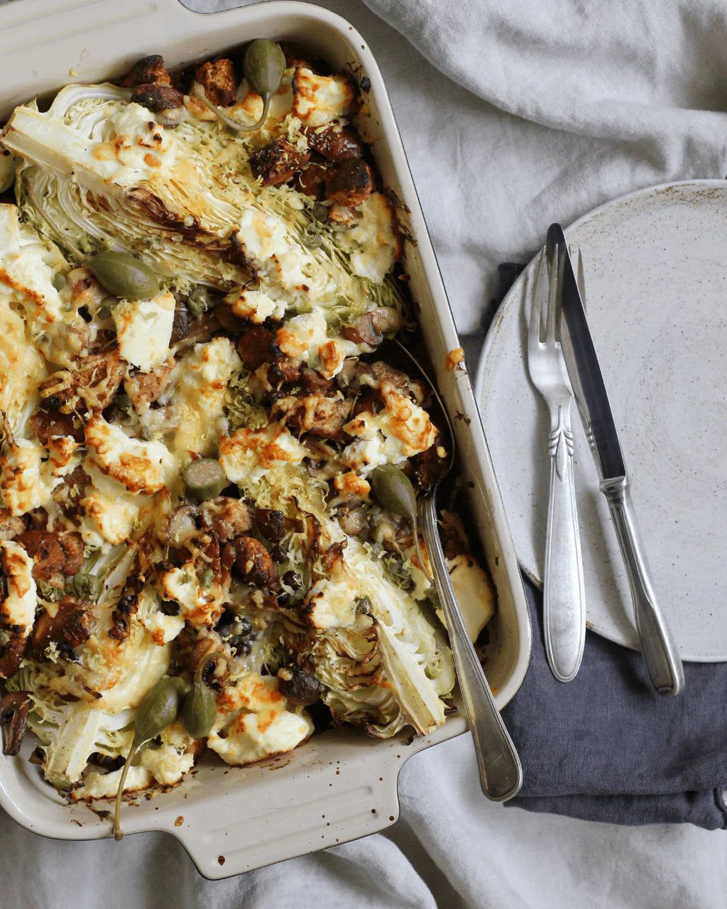 Gratineret spidskål med gråærter, ost og brune svampe