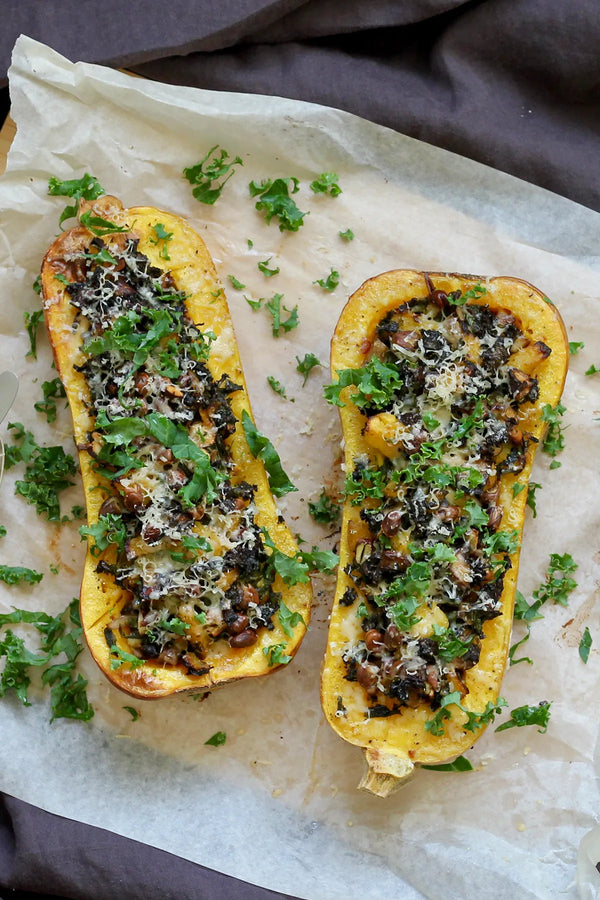 Bagt græskar fyldt med hestebønner, svampe og grønkål